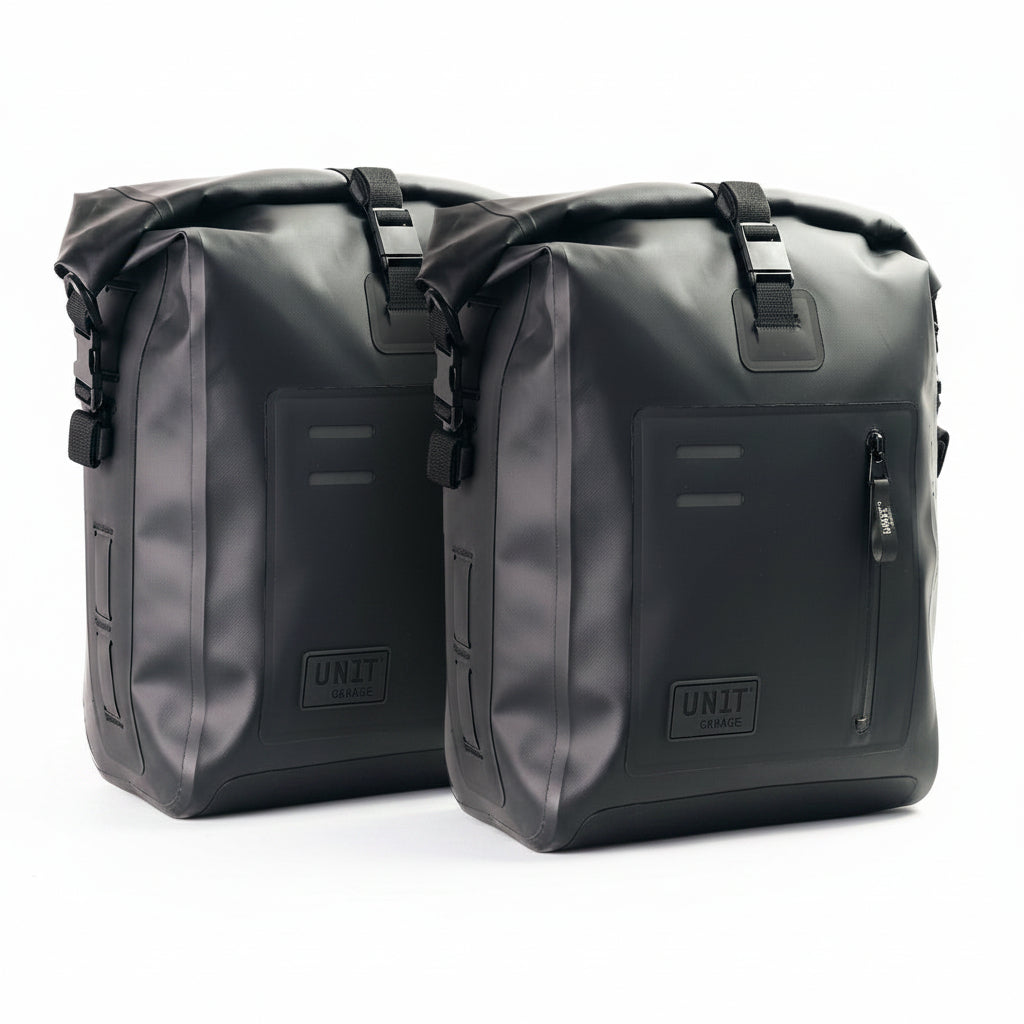 Two black motorcycle saddlebags with 'UNIT Garage' branding on a white background.